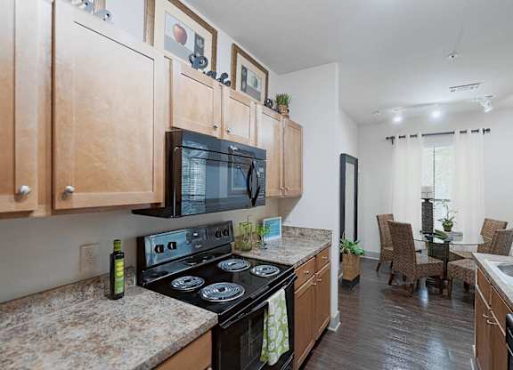 A kitchen with wooden cabinets and a black stove top oven.