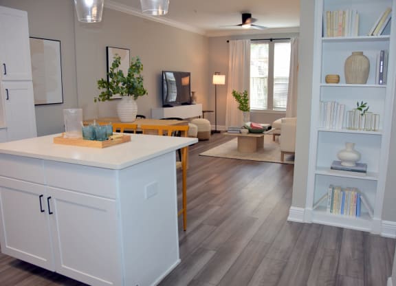 a kitchen and living room with white cabinets and a table