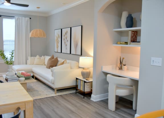 a living room with a couch and a desk and a window