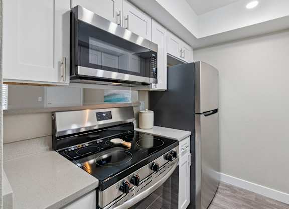 A modern kitchen with a stainless steel stove and microwave above it.