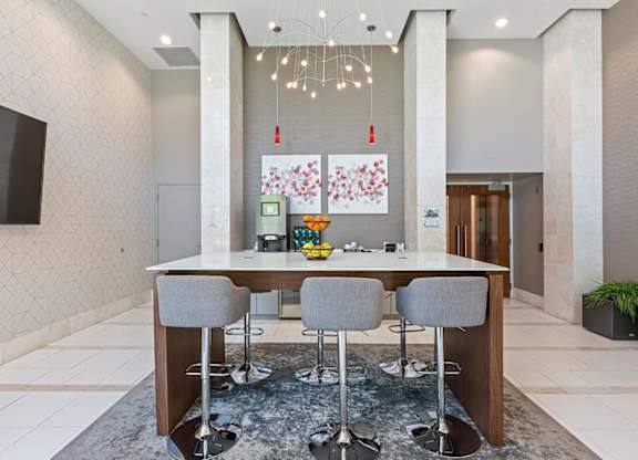 A modern dining area with a long table and grey chairs.