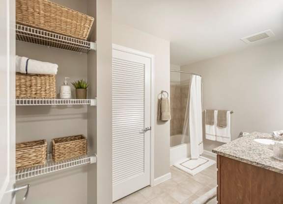 A bathroom with a white door, a white sink, and a white counter.
