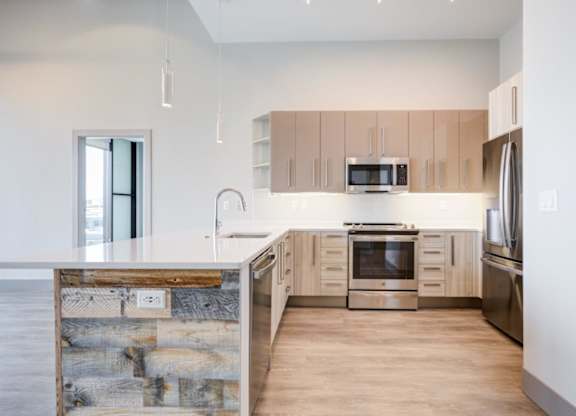A modern kitchen with wooden cabinets and stainless steel appliances.