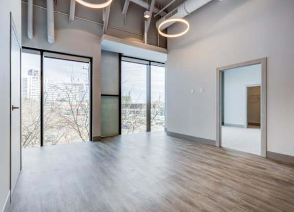 A room with a view of the city through large windows.