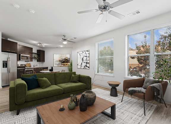 A living room with a green couch, a brown armchair, and a wooden coffee table.