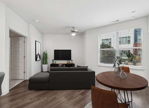 A modern living room with a black sofa and a grey armchair.