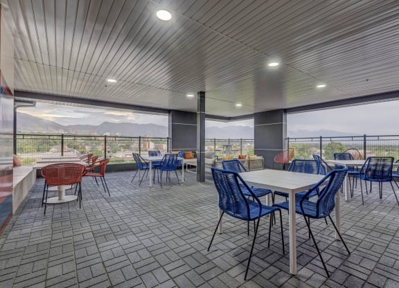 a cafeteria with tables and chairs and a view of mountains