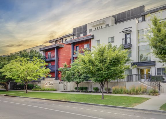 an apartment building on a city street with trees