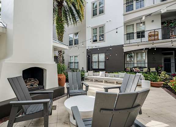 A patio with chairs and a fireplace.