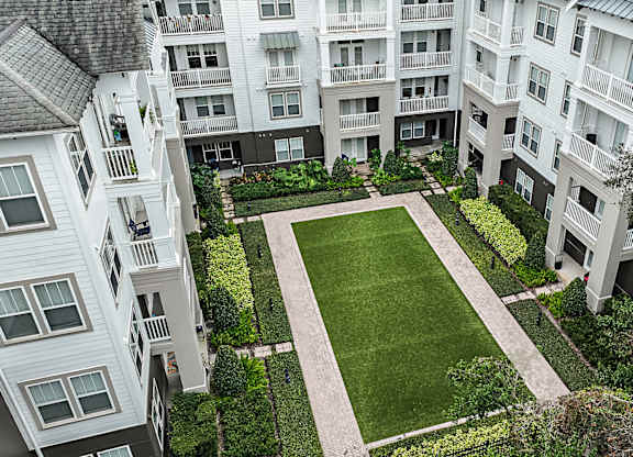 A large grassy area surrounded by buildings.