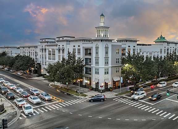 A large white building with a green dome is in the background of a busy intersection.
