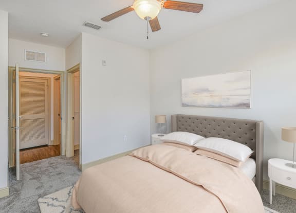 a bedroom with a bed and a ceiling fan