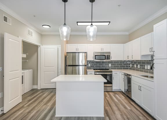 a kitchen with white cabinets and a white island