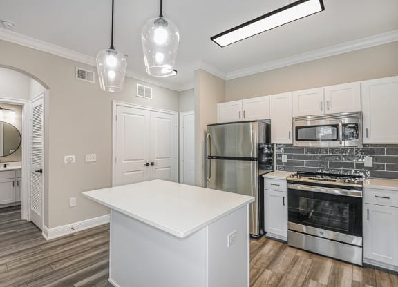 a kitchen with white cabinets and stainless steel appliances