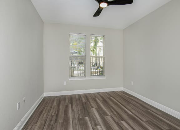 a bedroom with hardwood floors and grey walls