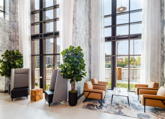 a lobby with couches and chairs and large windows at 100 House Apartments, Jersey City , NJ, 07310