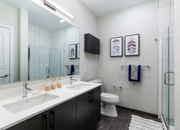 a bathroom with two sinks and a shower and a toilet at 100 House Apartments, New Jersey