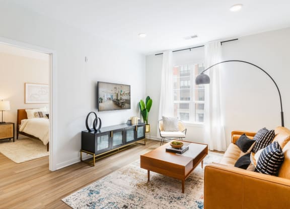 a living room with a couch and a coffee table    and a bedroom at One Ten Apartments, Jersey City , NJ