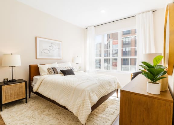 a bedroom with a bed and a large window at One Ten Apartments, New Jersey, 07310