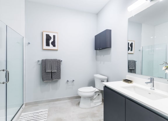 a bathroom with a toilet and a sink and a shower at One Ten Apartments, New Jersey