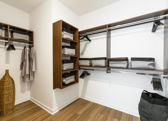 a walk in closet with wooden shelves and a white wall with a window at One Ten Apartments, Jersey City , NJ