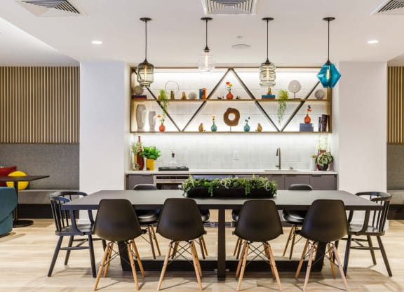 a dining area with a table and chairs and a kitchen in the background at One Ten Apartments, New Jersey, 07310