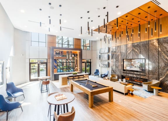 a living room with a fireplace and a pool table at One Ten Apartments, Jersey City , NJ