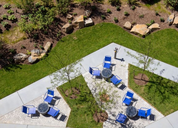 a patio with blue chairs and tables in a park at One Ten Apartments, Jersey City , NJ, 07310