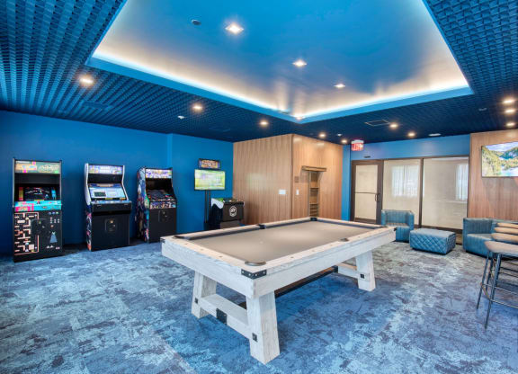 a game room with a pool table and arcade machines at One Ten Apartments, Jersey City , NJ