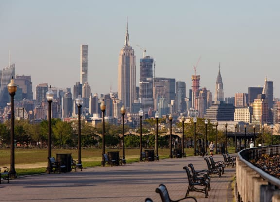 a view of the city skyline from a park with benches at One Ten Apartments, Jersey City , NJ, 07310