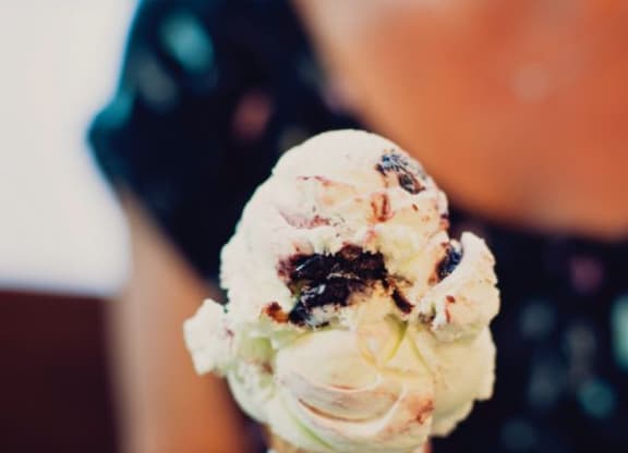 a person holding a cone with ice cream at One Ten Apartments, New Jersey