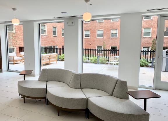 a seating area with a couch and tables in front of a window at Carver and Slowe Apartments, Washington Washington, DC