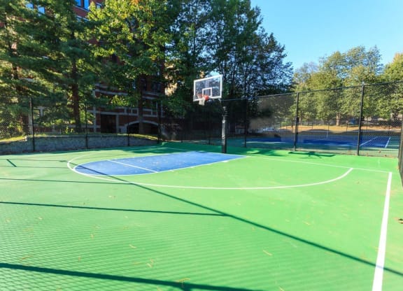a tennis court with a basketball court in the background