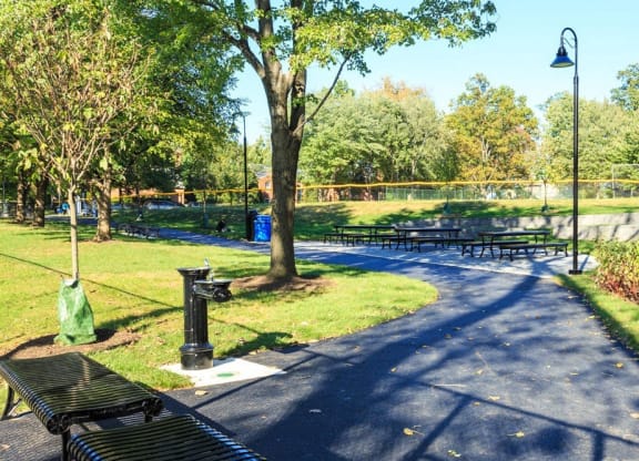 a path in a park with benches and trees at The Saratoga Apartments, Washington