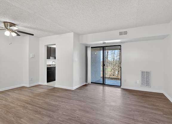 A room with a sliding glass door leading to a backyard.