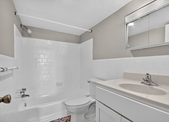 A white bathroom with a sink, toilet and bathtub.