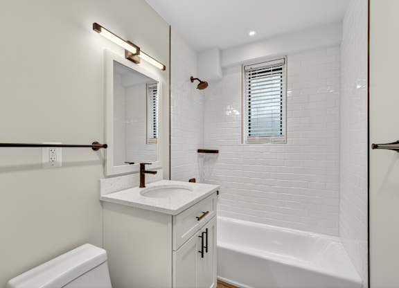 A white bathroom with a toilet, sink, and bathtub.