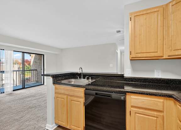 A kitchen with wooden cabinets and a black countertop.