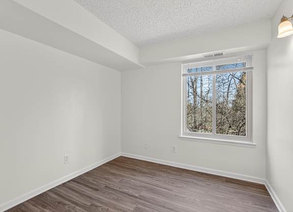 A room with a window and wooden flooring.