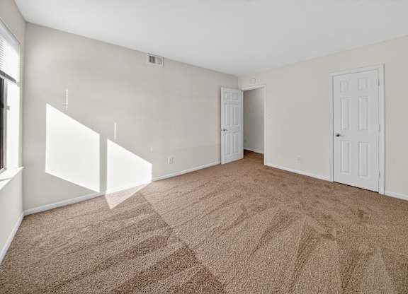 A room with carpeted floor and white walls.