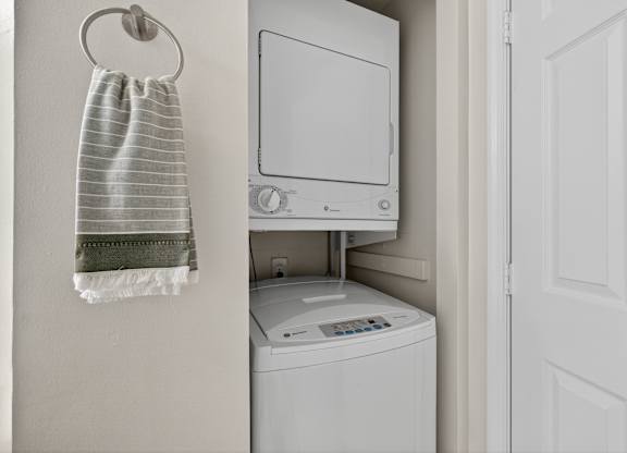 A white washing machine is in a small laundry room.