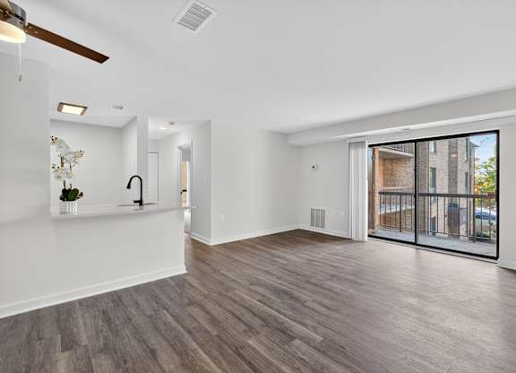 A spacious room with a ceiling fan and sliding glass doors.
