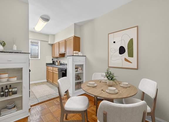 A kitchen with a table and chairs in front of it.
