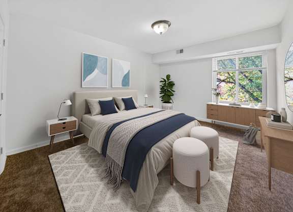 A bedroom with a large bed and a window overlooking trees.