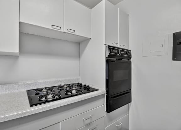 A black and white photo of a kitchen with a stove and oven.
