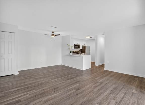 A room with wooden floors and a ceiling fan.