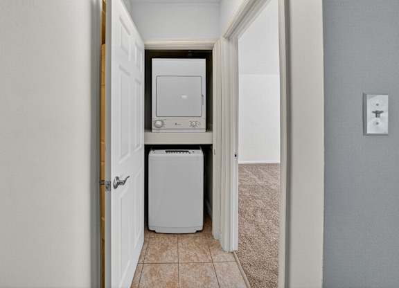 A white washing machine and dryer is in a hallway.