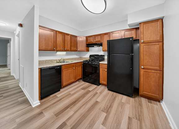A kitchen with wooden cabinets and black appliances.