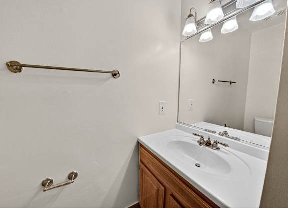 A bathroom with a white sink and a white towel rack.