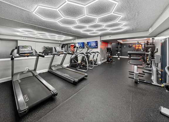 A gym with treadmills, exercise bikes, and other equipment.